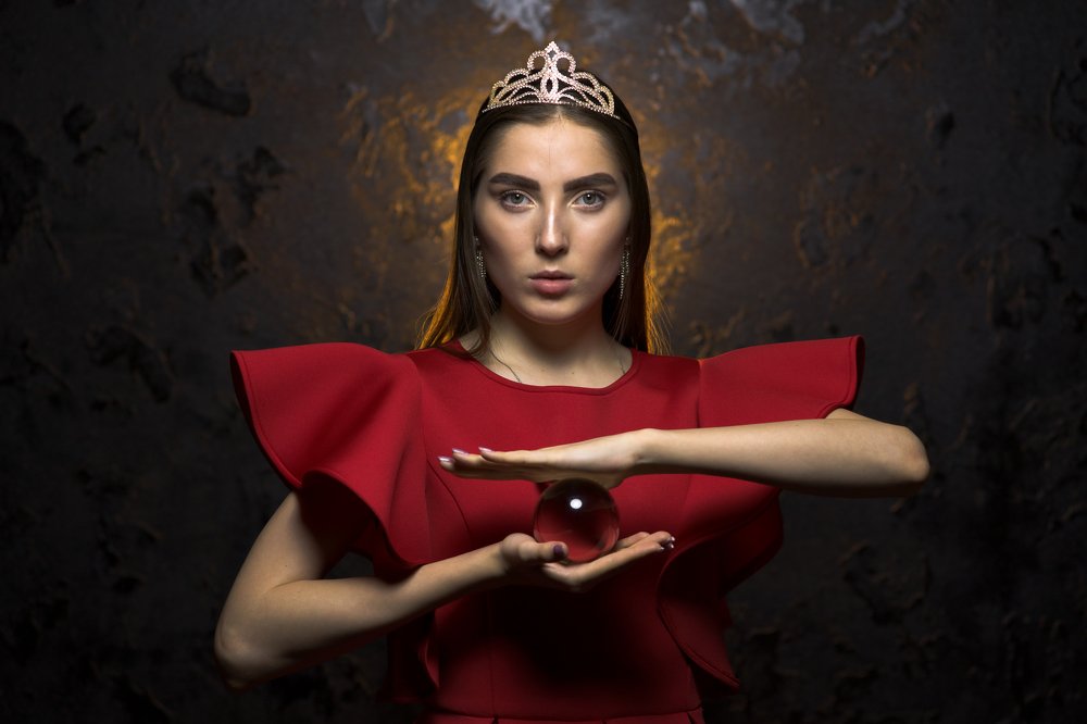 Portrait of a young woman in crown and red dress