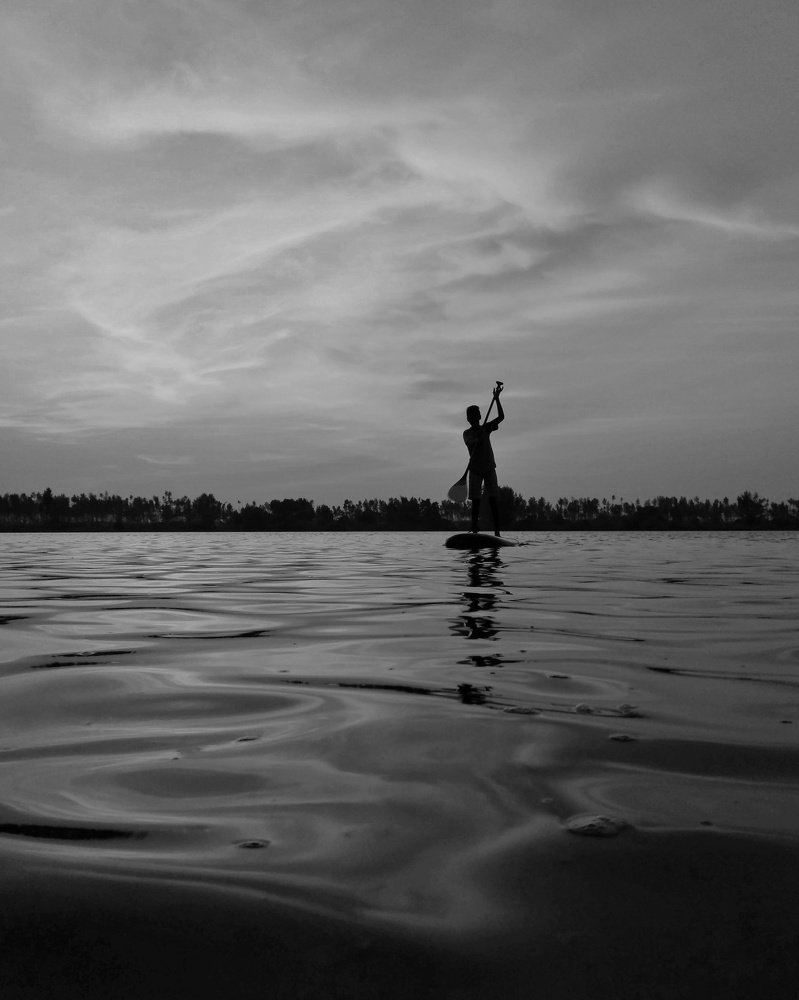 The stand up paddleboarding boy
