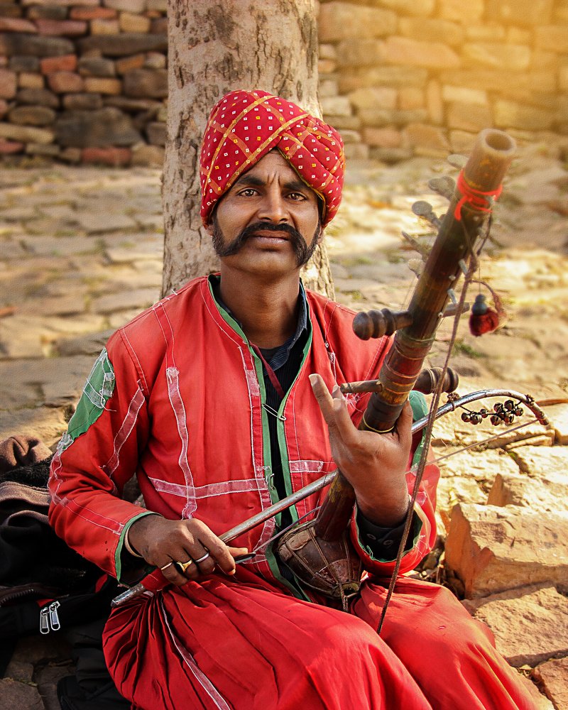 A man playing Ravanhatta instrument