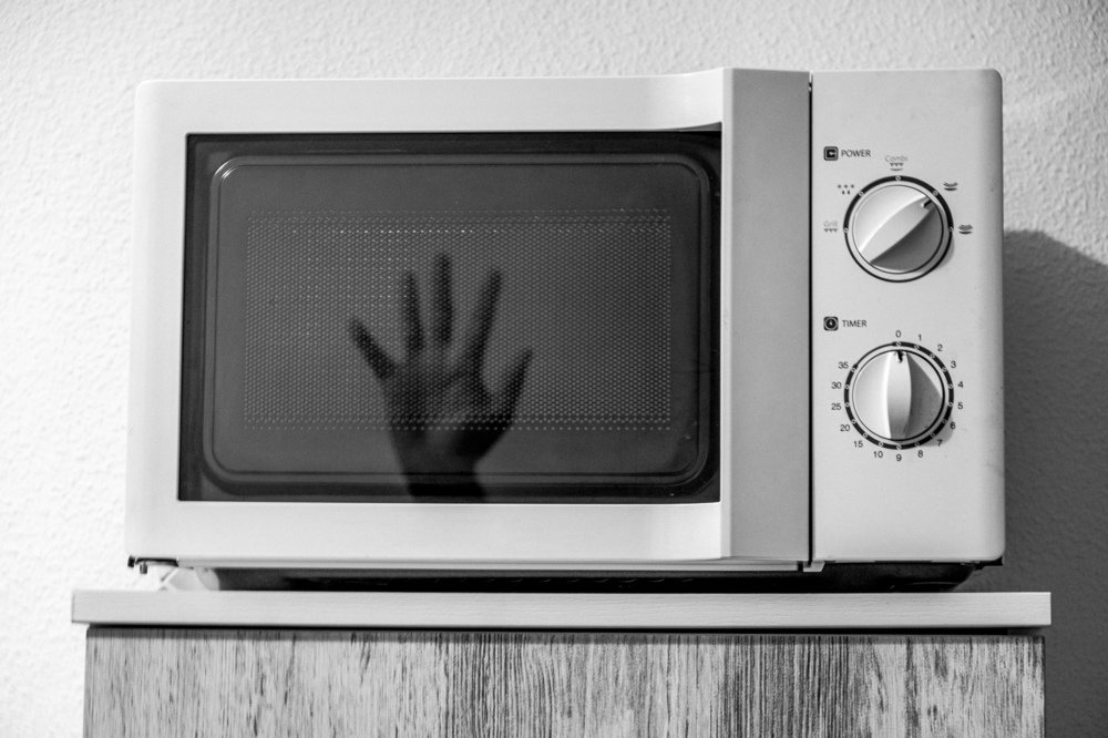 Hand inside microwave