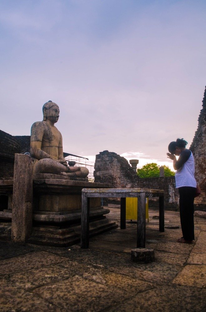 Lady worshiping Lord Buddha