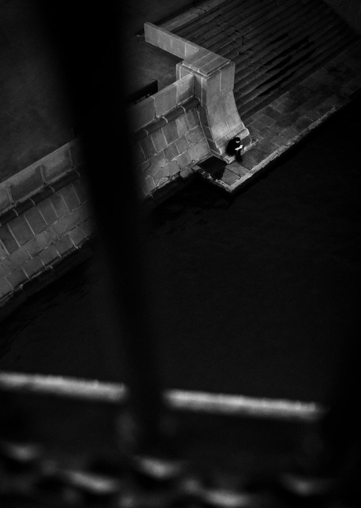 Lonely woman reading a book on the river bank