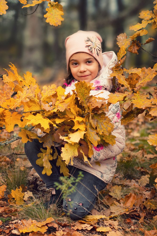 Girl with a bouquet of autumn leaves