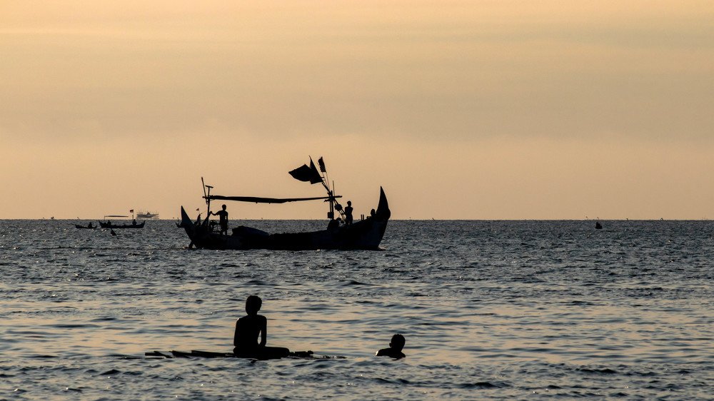 Two small children bathe in the sea