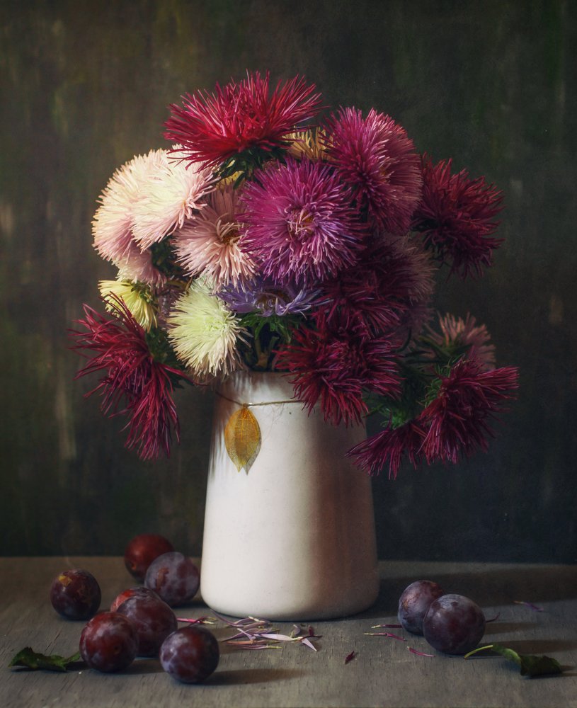 A bouquet of flowers and ripe plums
