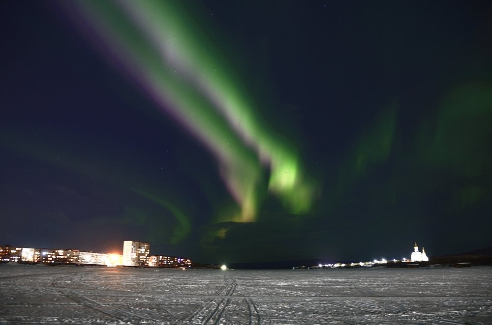 Лента сияния над вечерним городом.
