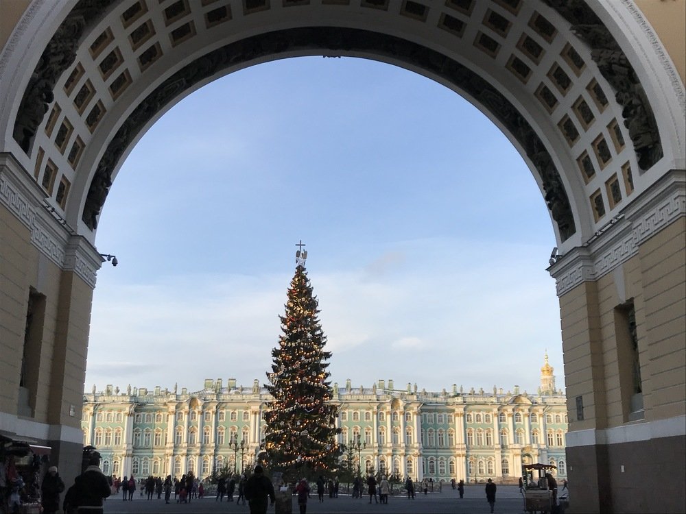 Дворцовая площадь и Эрмитаж через арку Главного штаба. Ангел-Хранитель с крестом возвышается над новогодней елью.