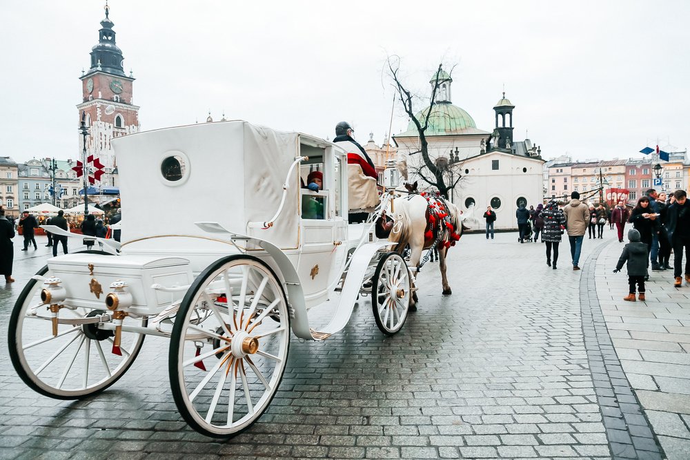 Белая карета с лошадьми в центре старого города