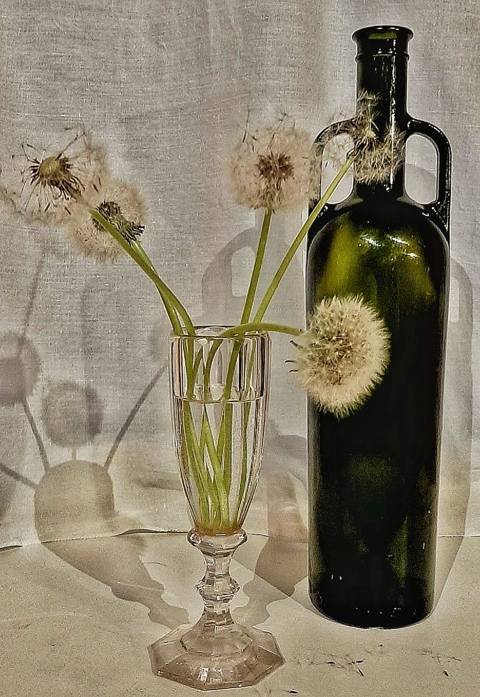 Одуванчики в фужере и зелёная бутылка