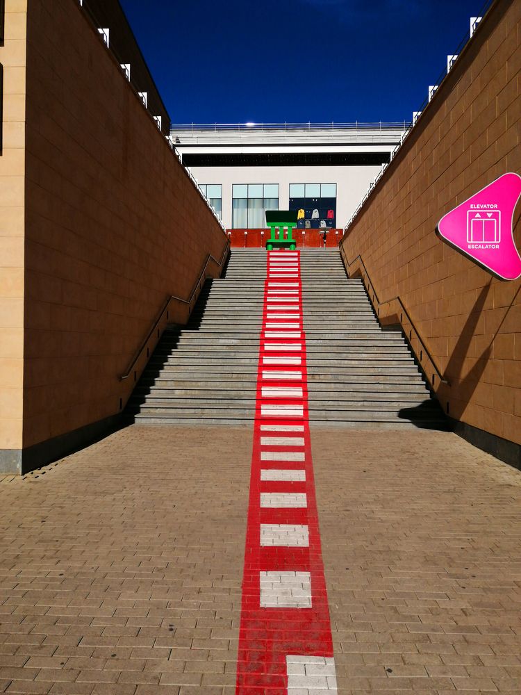 Лестница ведущая к зеленой скамейке.