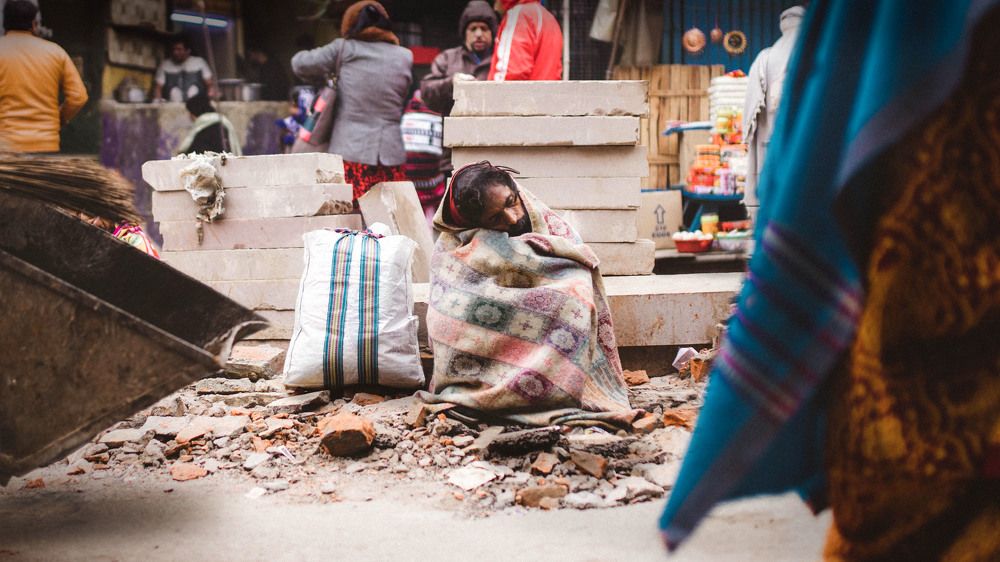 Homeless guy resting by the road side