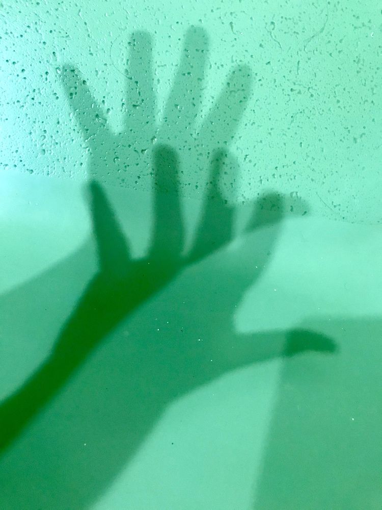 Shadow of green hands clappiing.