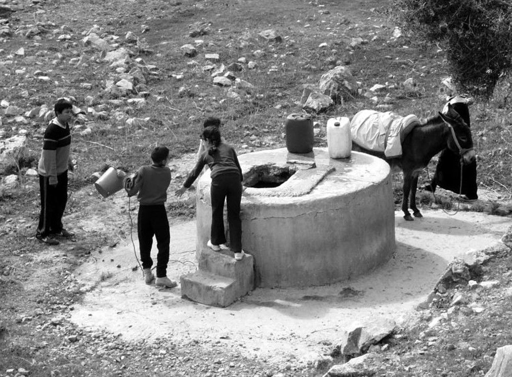 Children around the well in the countryside