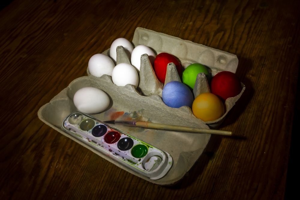 Multicolored chicken eggs for Easter and paints