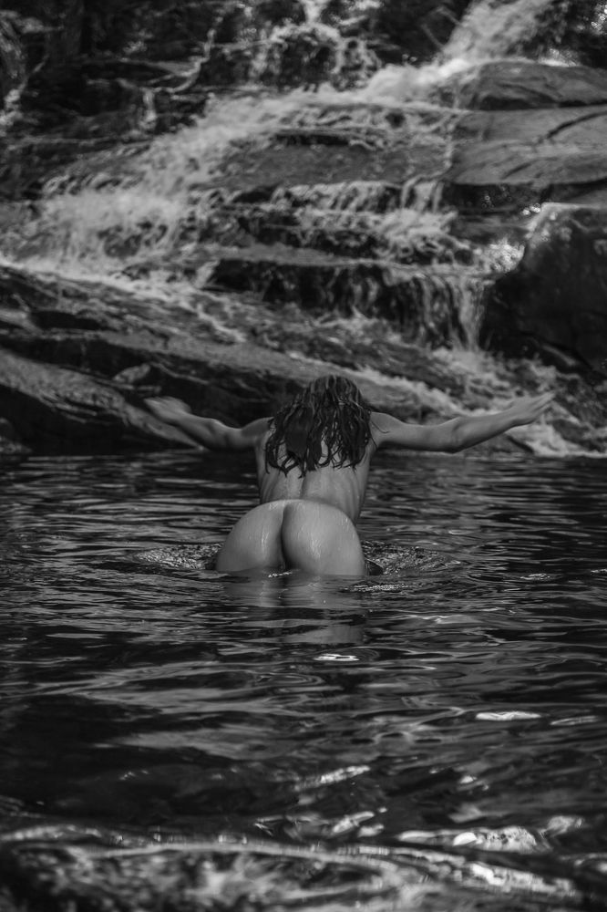 Beautiful woman in waterfall on bnw