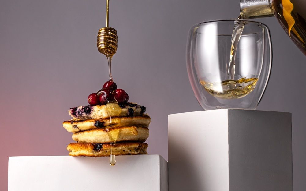 Pancakes with berries and honey and tea