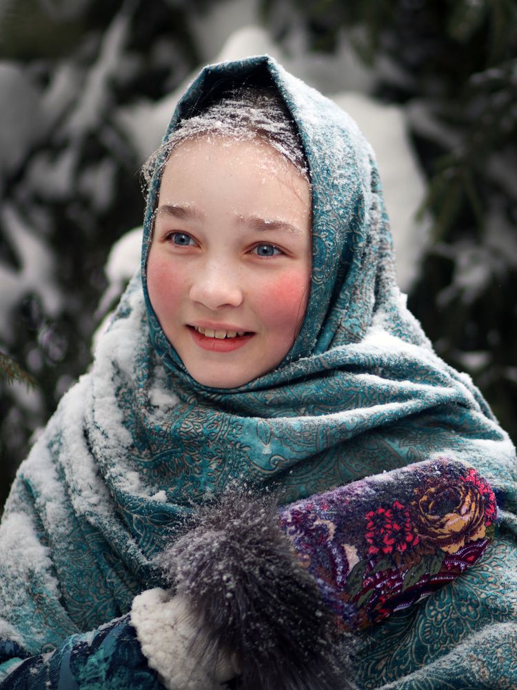 A girl in a blue scarf Covered with snow. Even the eyebrows are white