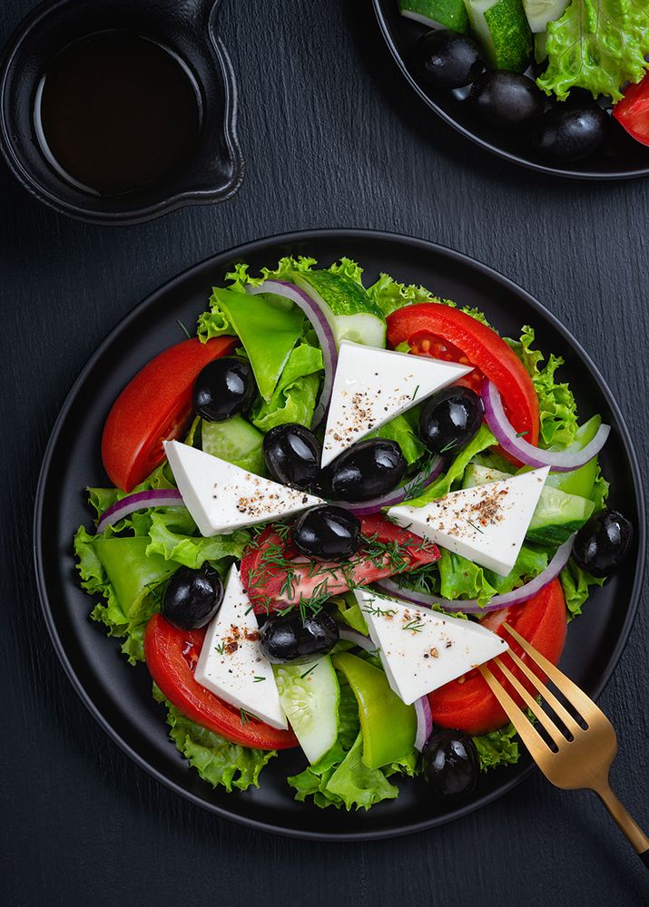 Vegetable salad with fresh cucumber, tomato, olive, onion, lettuce and feta cheese.