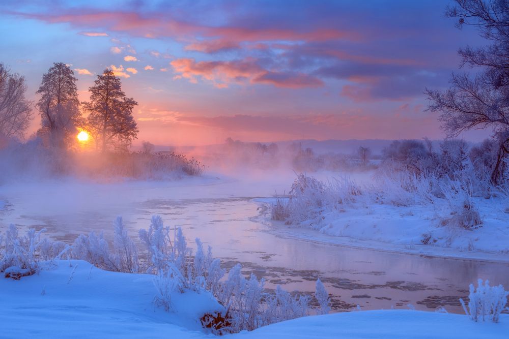 The sun rising over the misty river