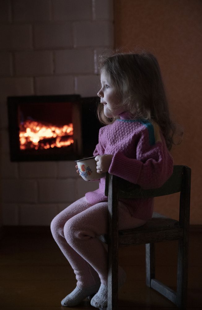 Ребёнок греется у печки