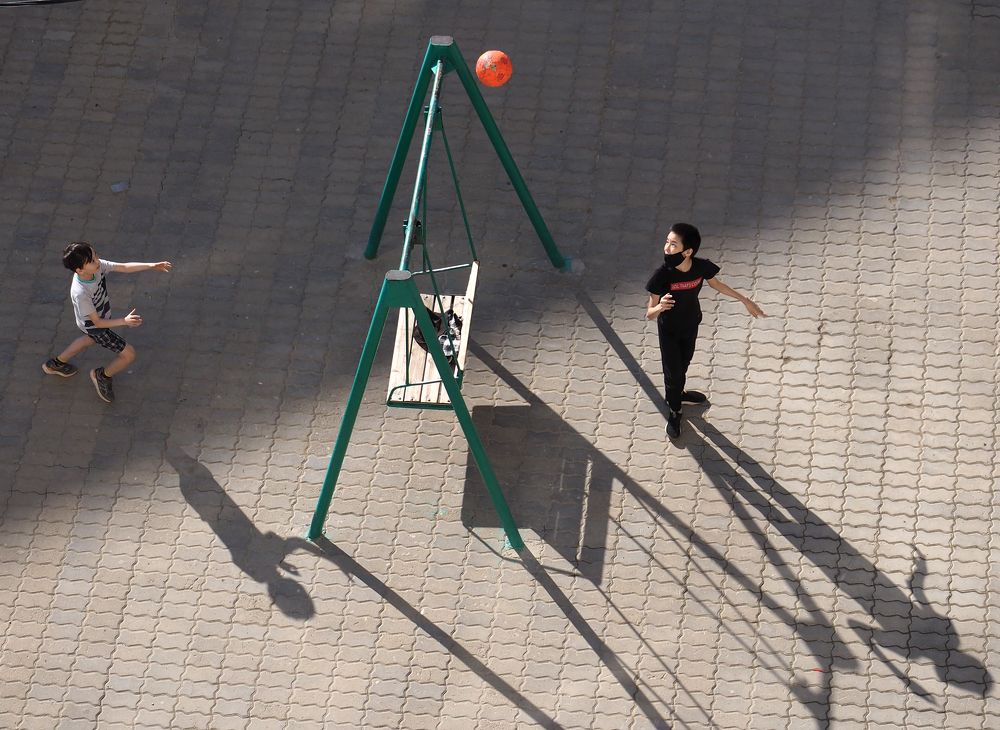 Мальчики, играющие в мяч во дворе