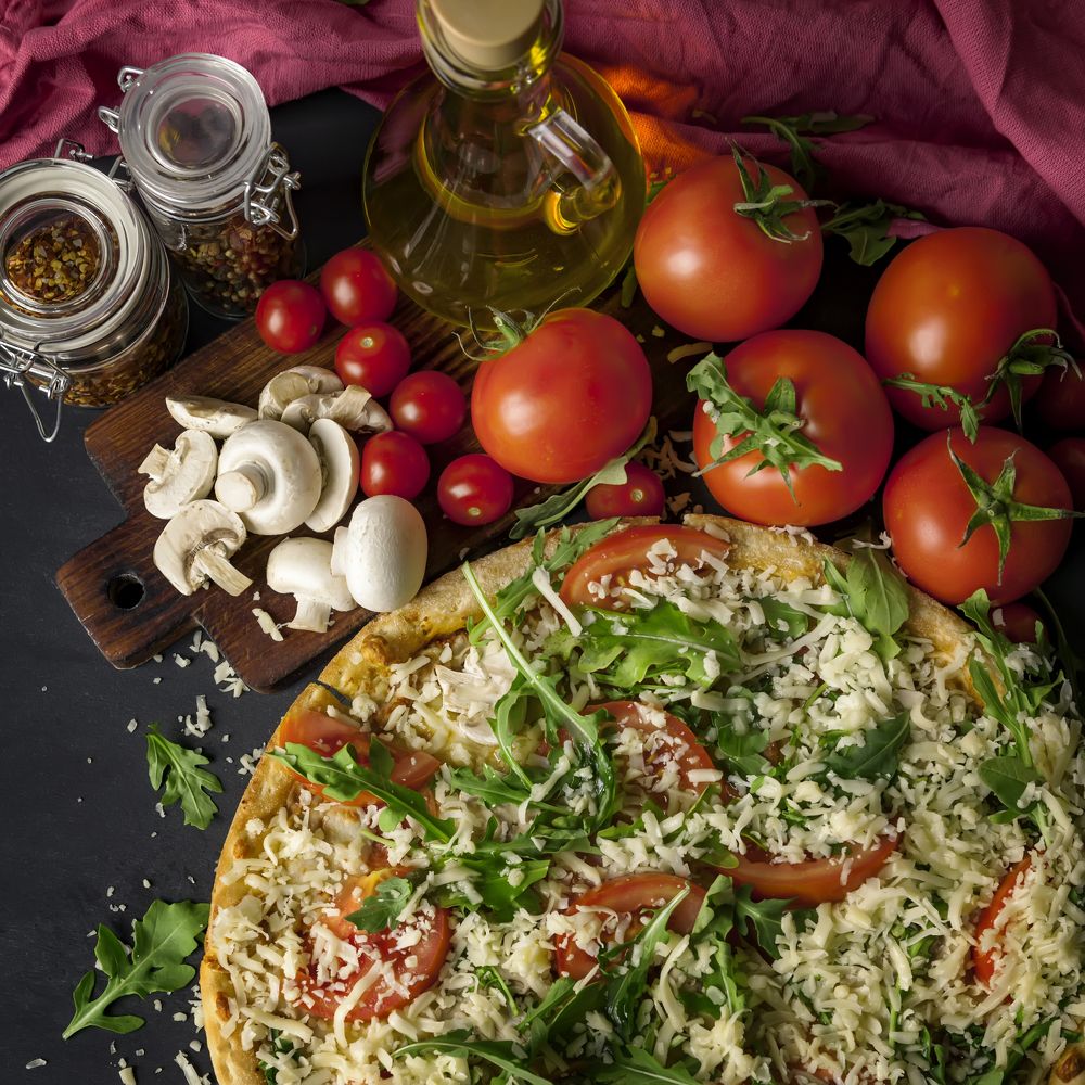 Готовая пицца из свежих овощей ,зелени и грибов.