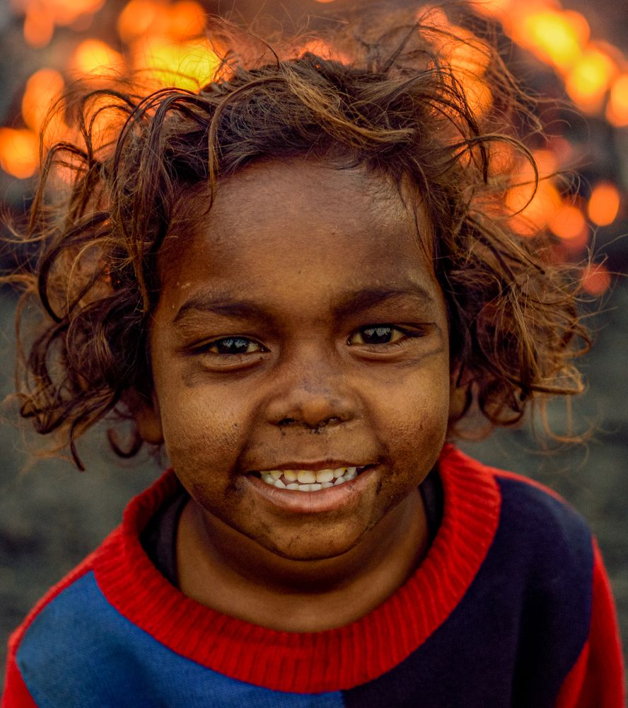 A smiling child with coal smudged face greeting me.
