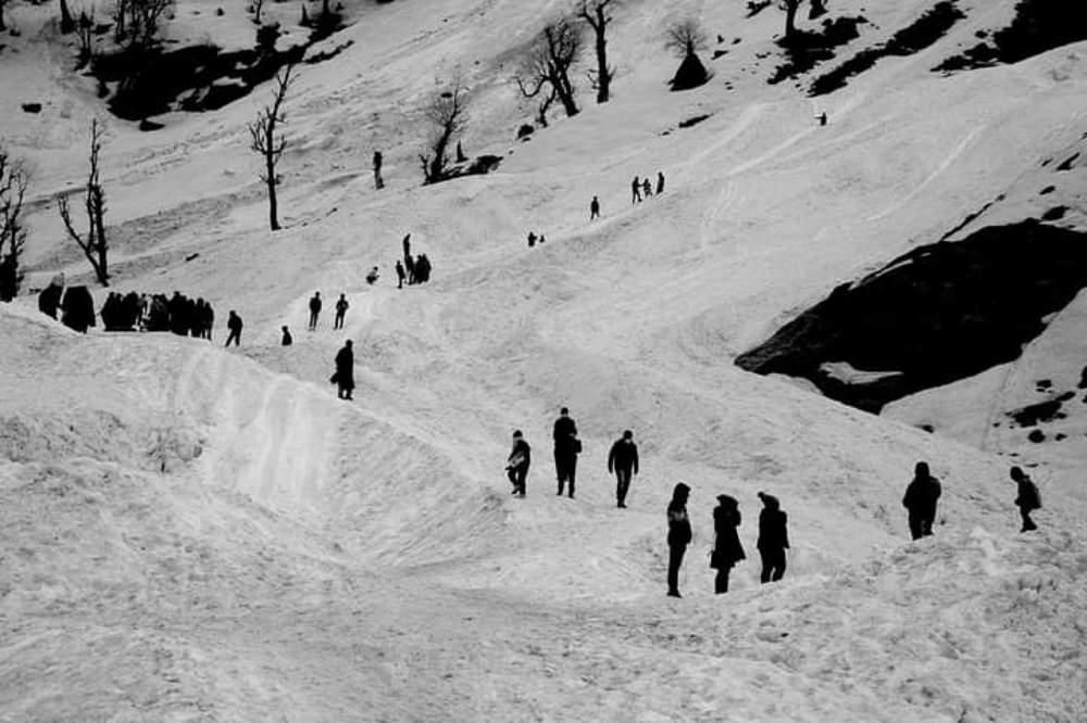 Travellers on snow covered road.