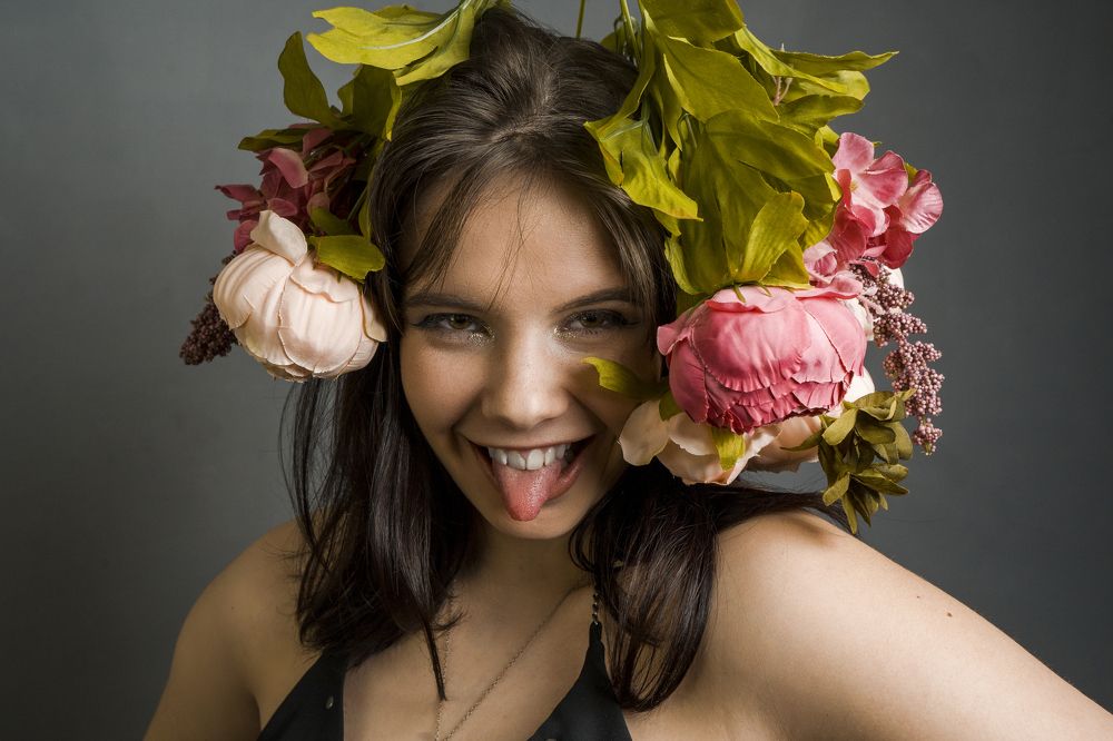 Улыбающаяся девушка с цветами на голове