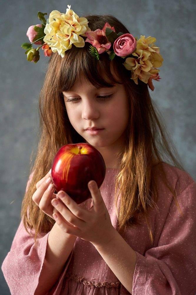 Девочка с яблоком и венком на голове
