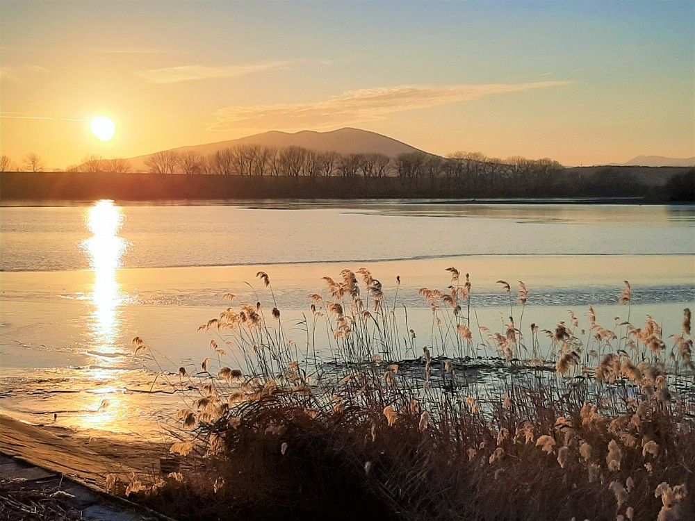 Západ slnka nad priehradou.