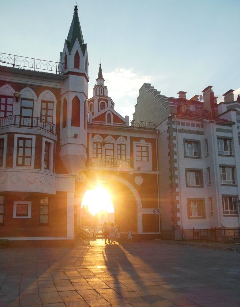 Закатное солнце в арке дома.