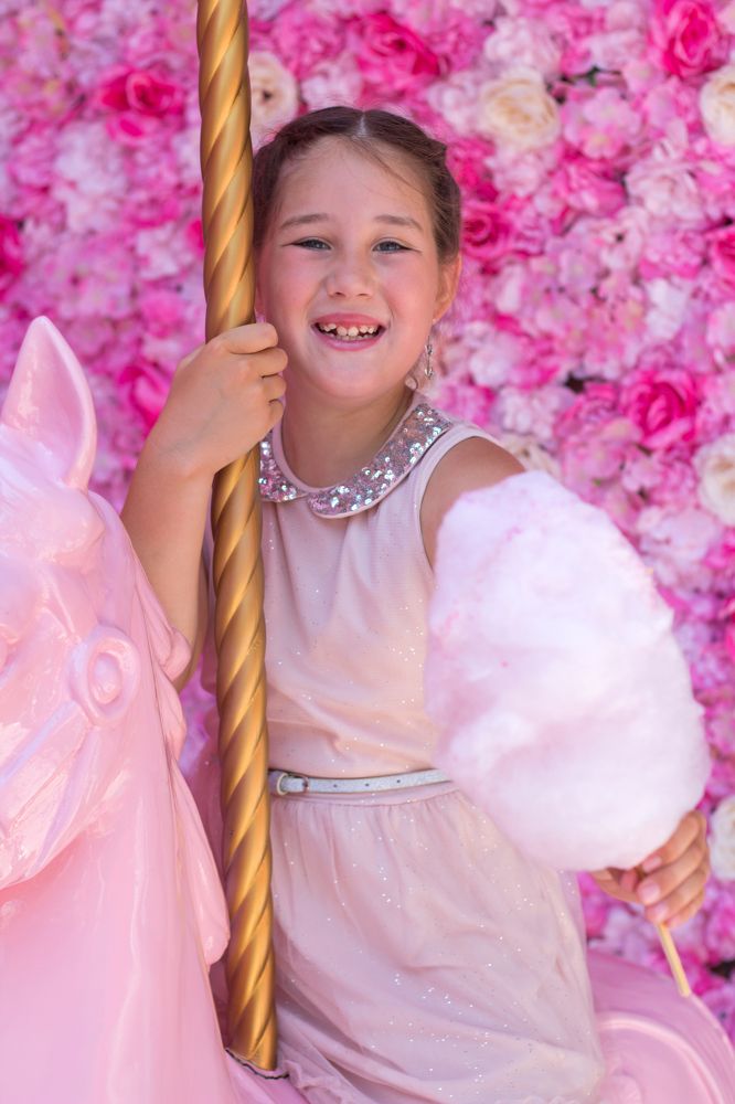 Девочка в розовом на карусели.