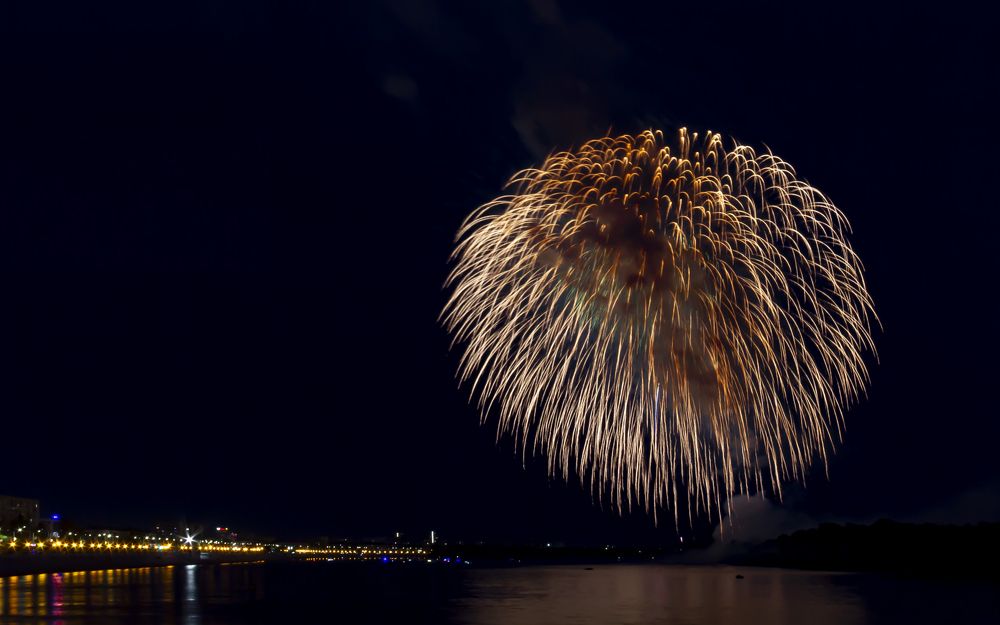 Ночной город на фоне фейерверка.