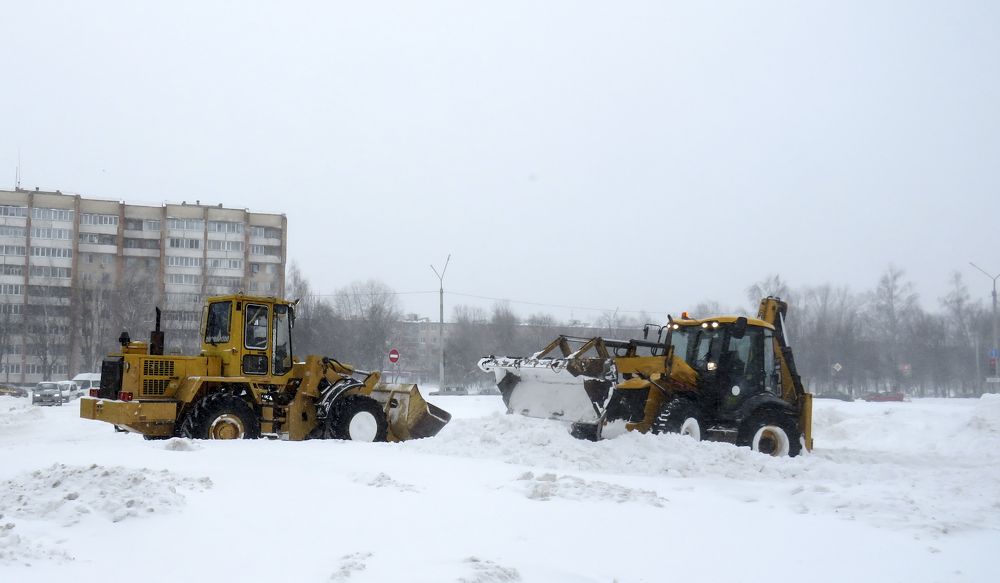 Tractors clear the road from snow