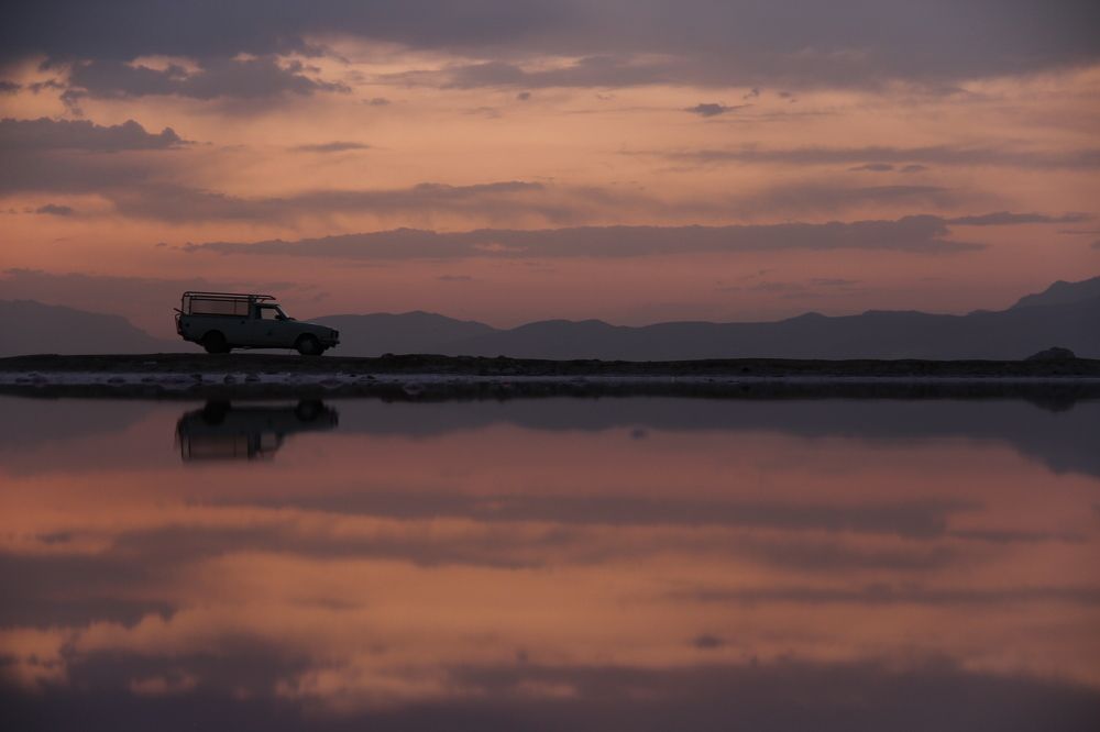 an old pickup on a wharf in middle of a salt lake