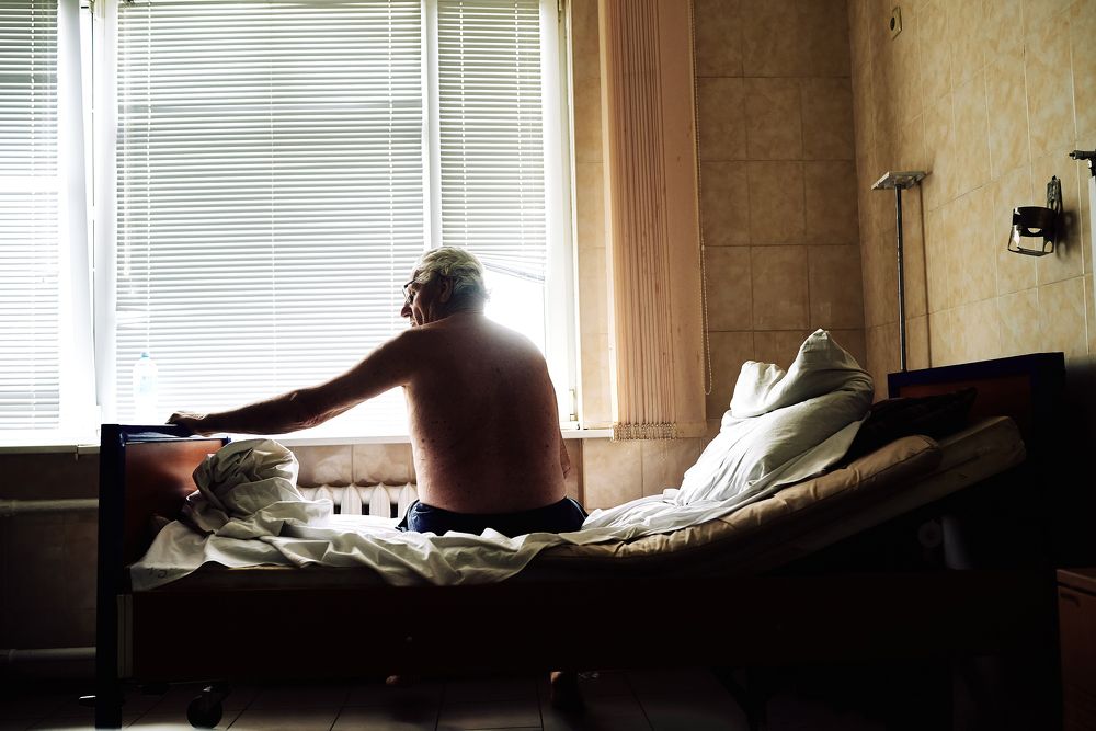 Репортажная фотография застывшего пенсионера, в раздумьях. Киевская больница, Хирургический корпус