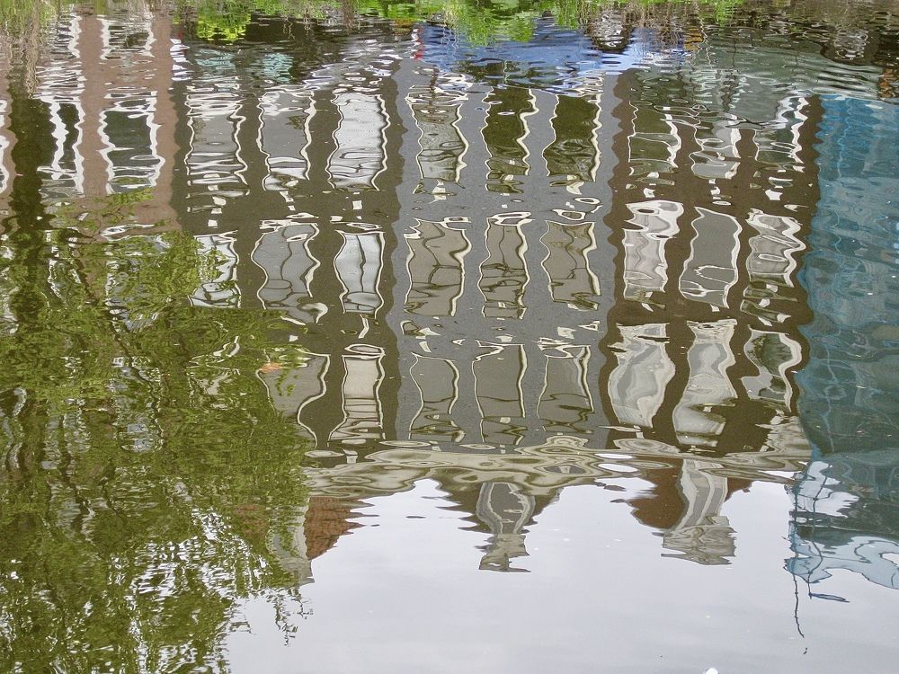 Причудливые отражения зданий в зеркальной глади канала г.Амстердама