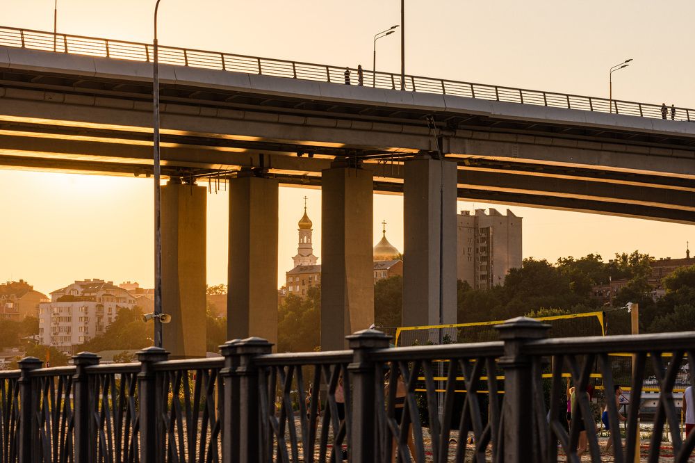 Ростов-на-Дону. Собор Рождества Пресвятой Богородицы в закатных лучах видимый сквозь опоры Ворошиловского моста