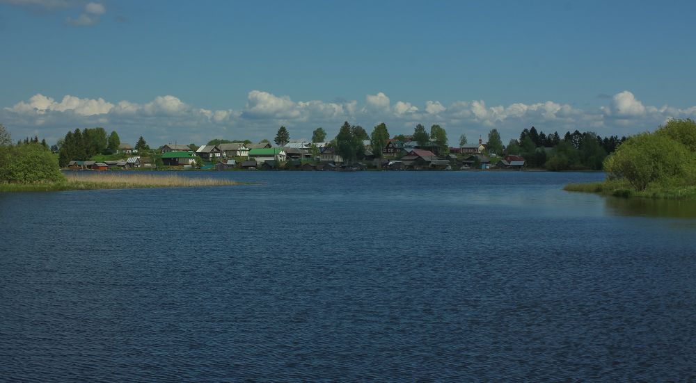 Lake Tatarovskoye and the coastal village of Krasnovo on a summer day
