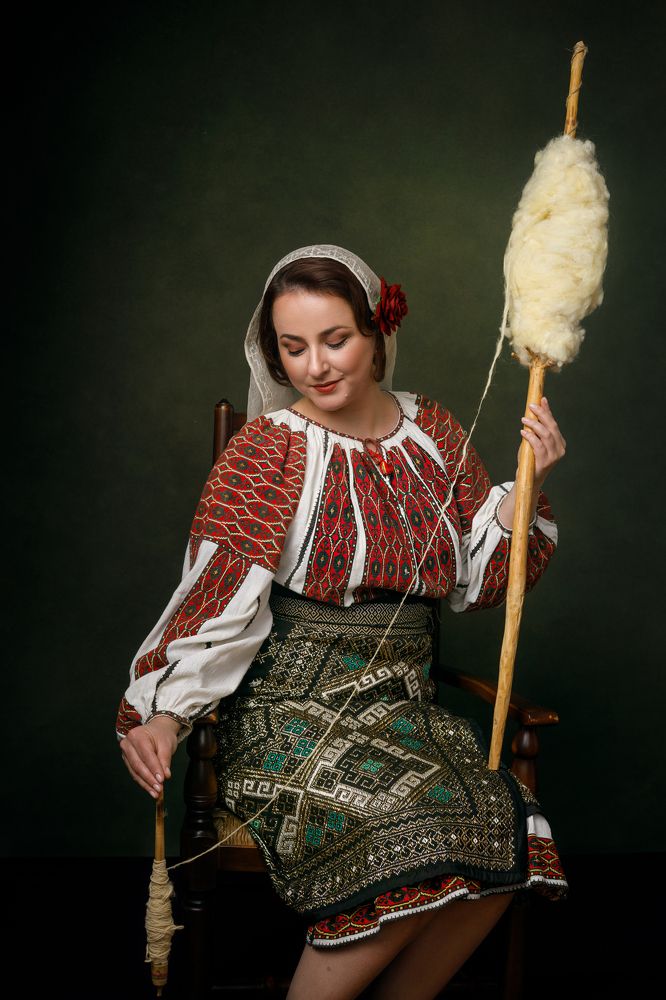 Woman in Romanian national costume spinning wool