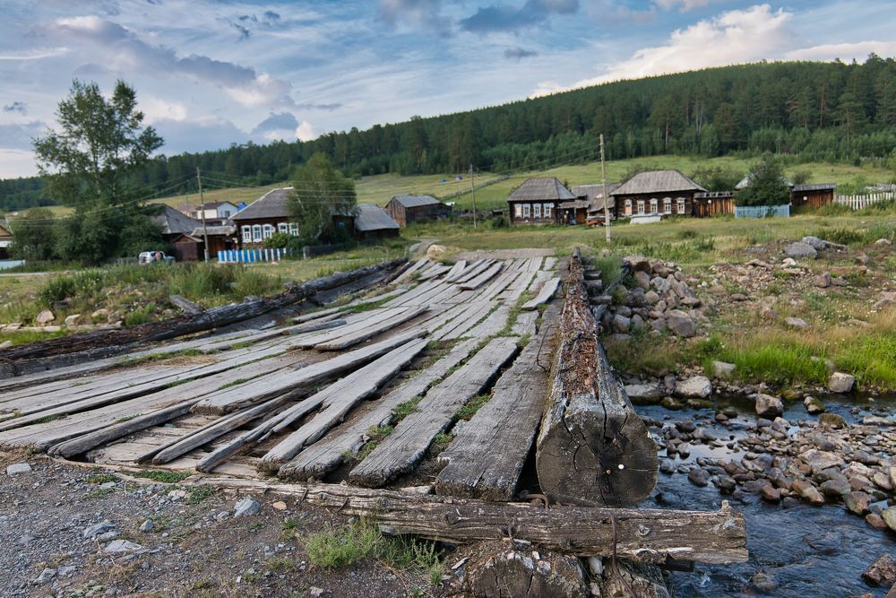 Ветхий деревянный мост в деревне на Урале