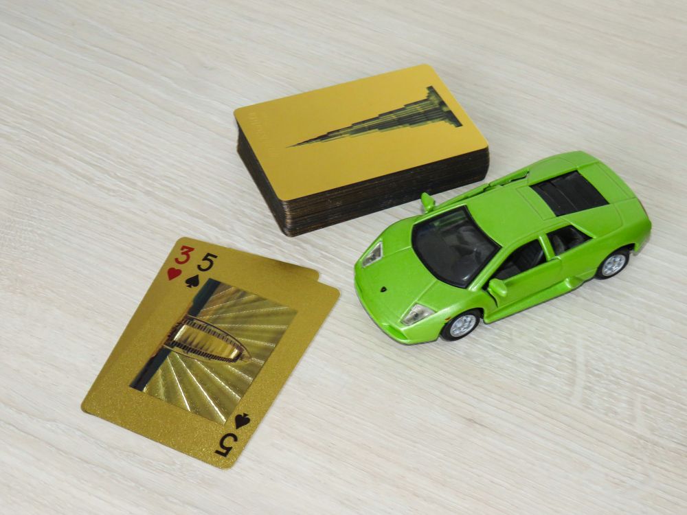 Green sports car and golden playing cards