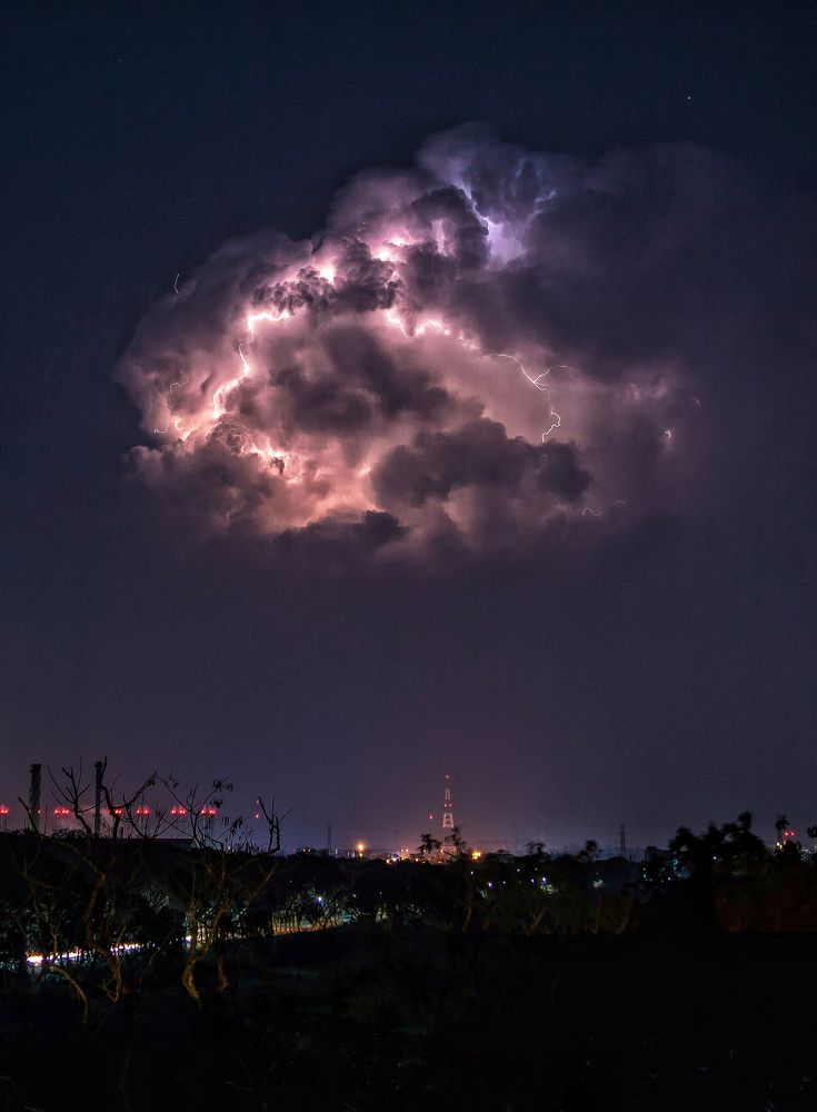 A bunch of lightning clouds over a city.