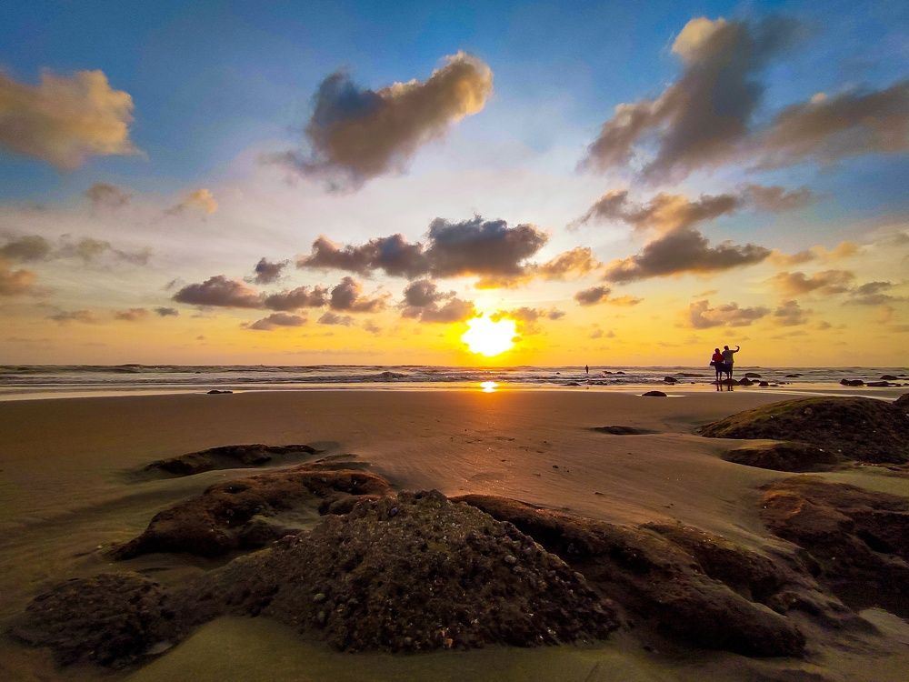 Two people were taking selfie at a seashore.