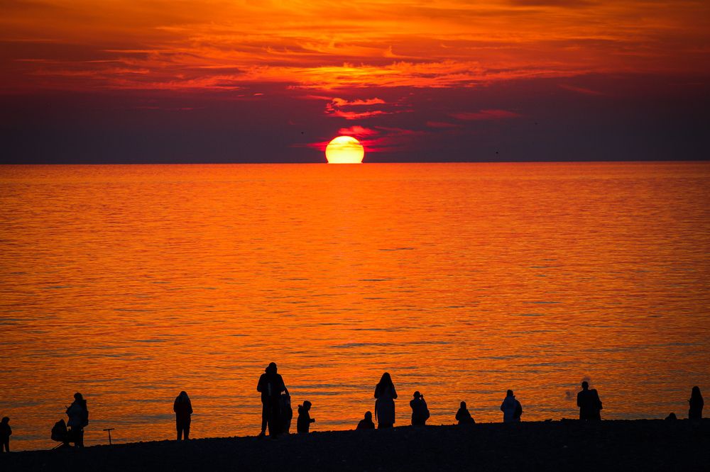 Люди наслаждаются закатом,