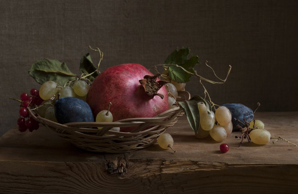 Гранат и фрукты в плетеной вазе