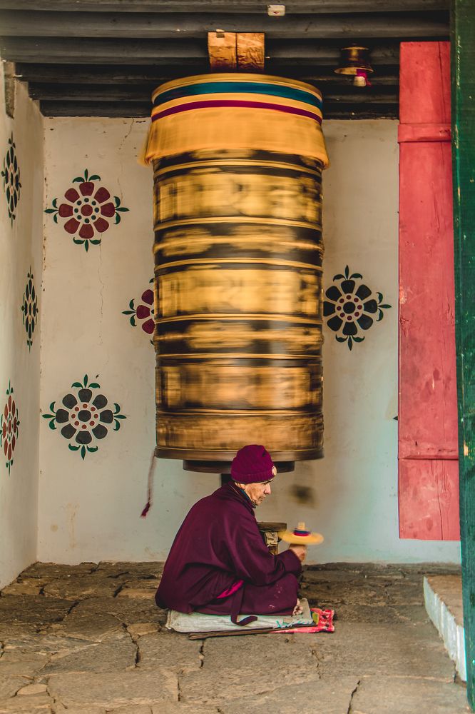 A lay monk multi-rotating two prayer wheels