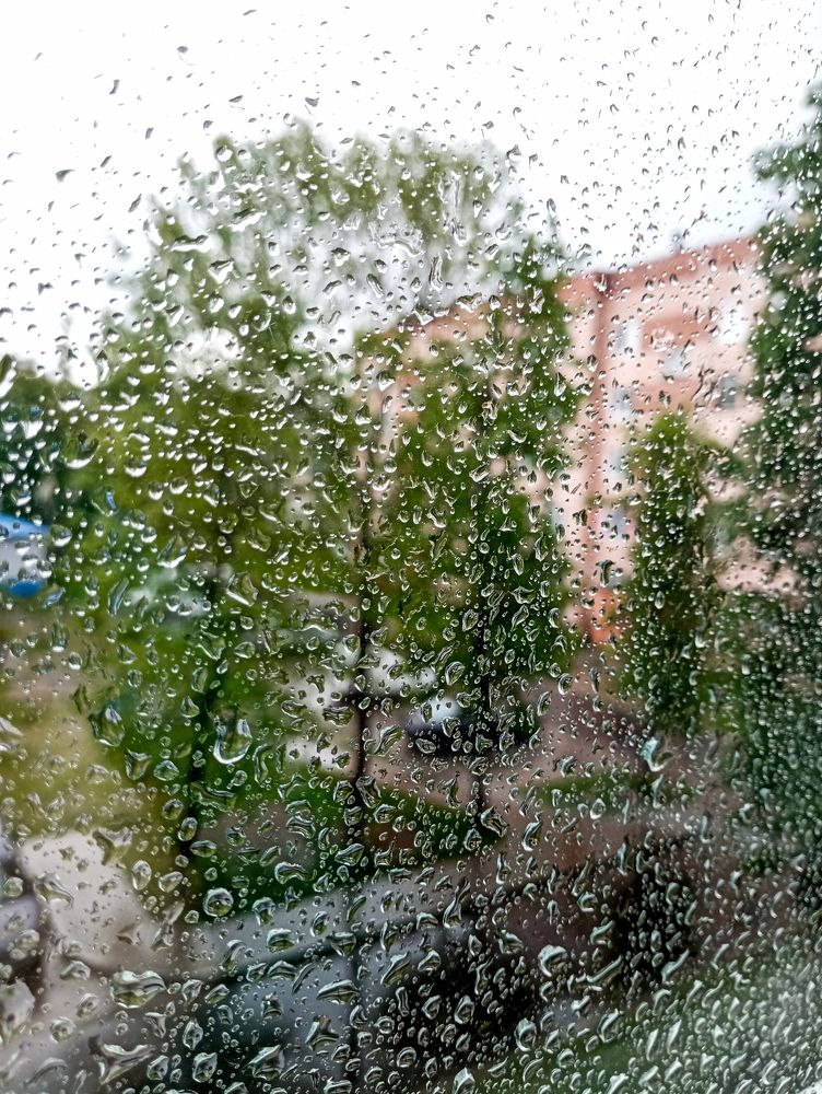 City through glass in raindrops