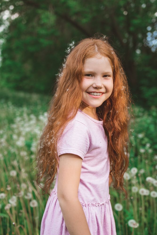 Рыжая девочка в одуванчиках